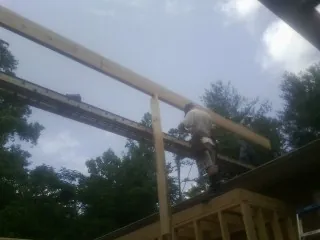 Carpenter setting a ridge beam over a new addition frame — Ice Dam Removal by Roofing Brothers in Yellow Pine