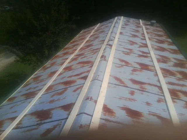 Rusted metal roof panels with new wood purlins before replacement — Storm Damage Roof Repair in Yellow Pine by Roofing Brothers