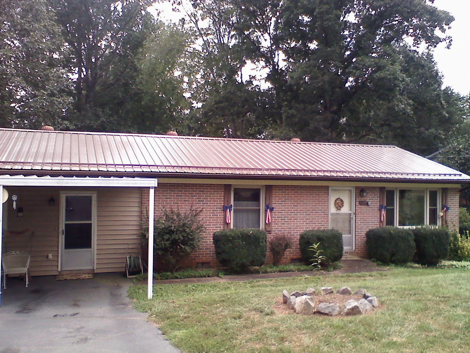 Bronze metal roof and carport on a brick ranch home — Roof Repair work by our crew in Yellow Pine